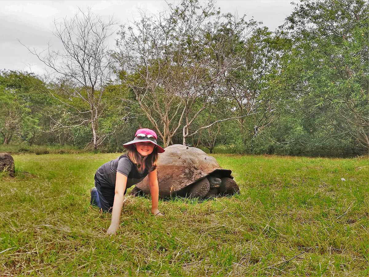 Little girl and tortoise on guided Galapagos Adventure Tour in Galapagos Islands