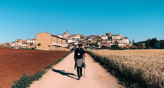 Hiker approaching the town in Spain on Camino de Santiago