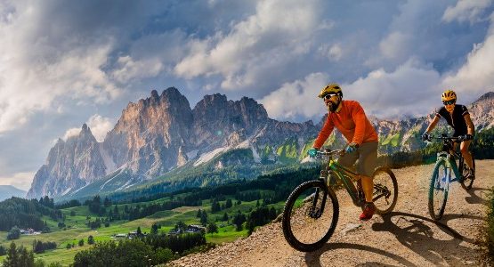 Two bikers e-bike riding in the Italian mountains