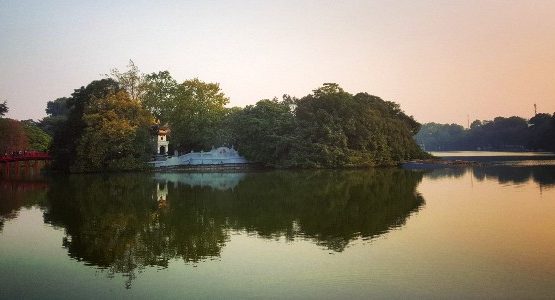 Calm river with trees, a white bulding, anda red bridge in Hanoi (1)