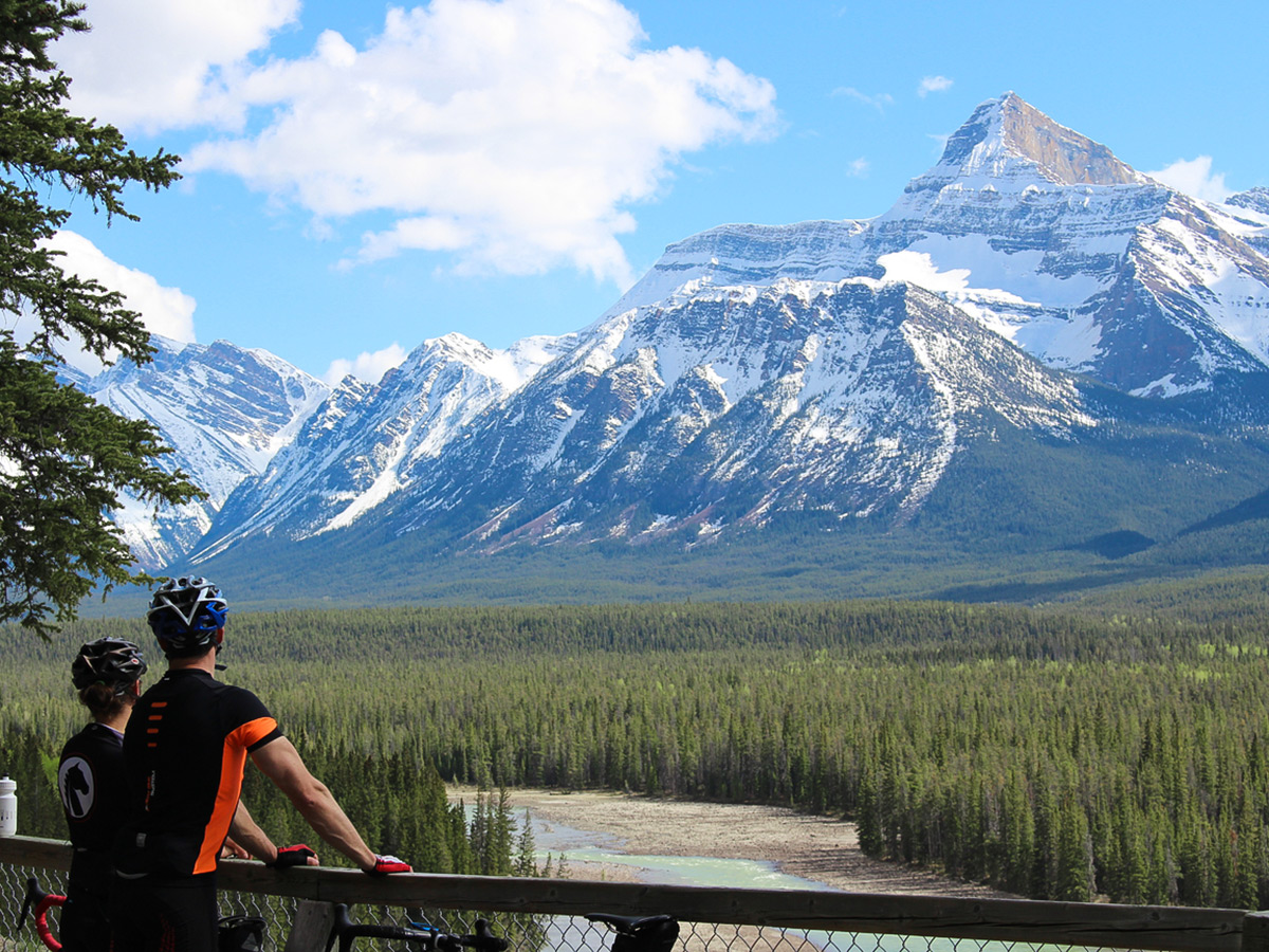 Two bikers looking at Canadian Rockies on guided cycling tour from Jasper to Banff in Canada