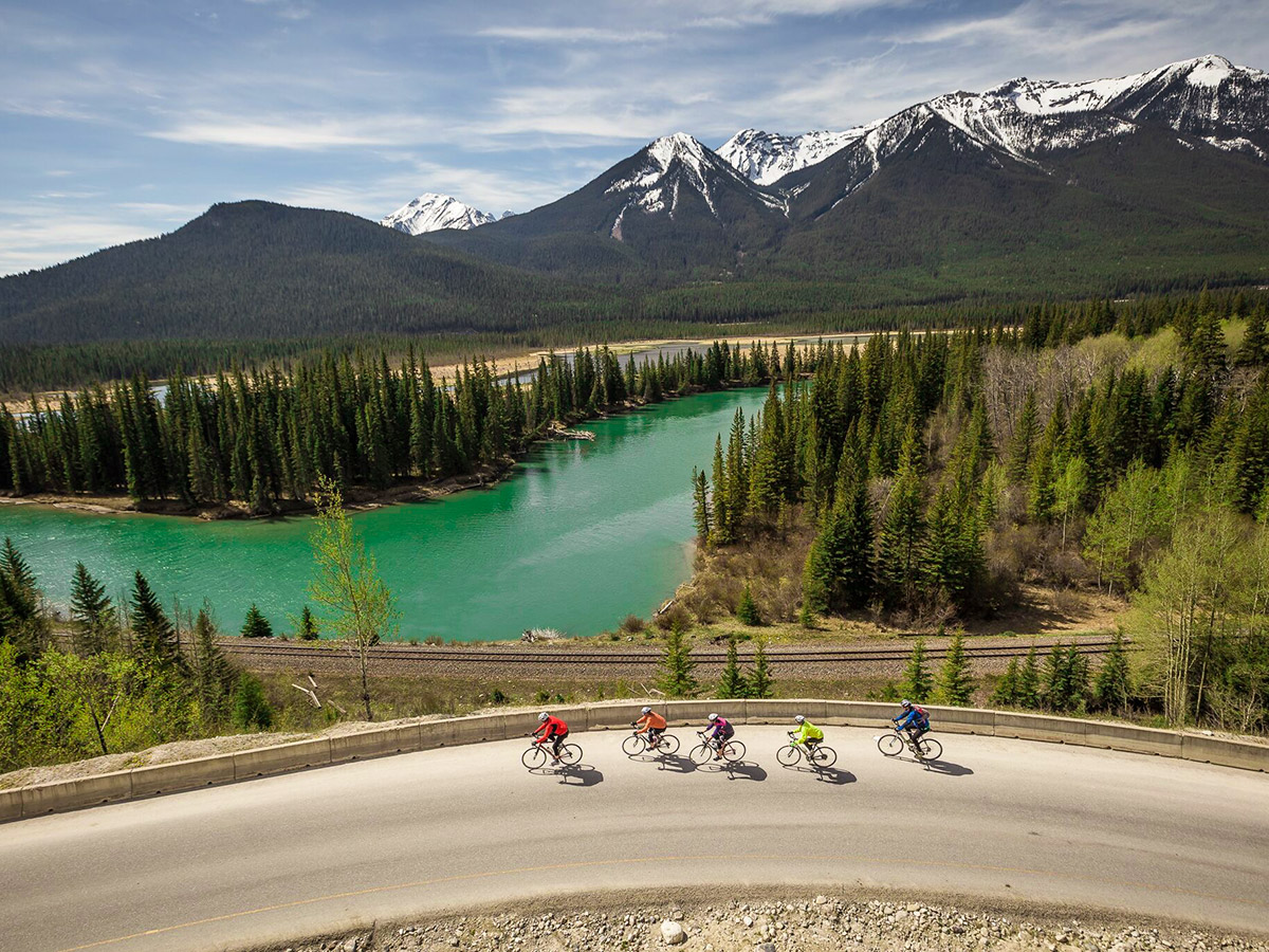 Bikers riding on Icefields Parkway surrounded by beautiful views on guided cycling tour from Jasper to Banff in Canada