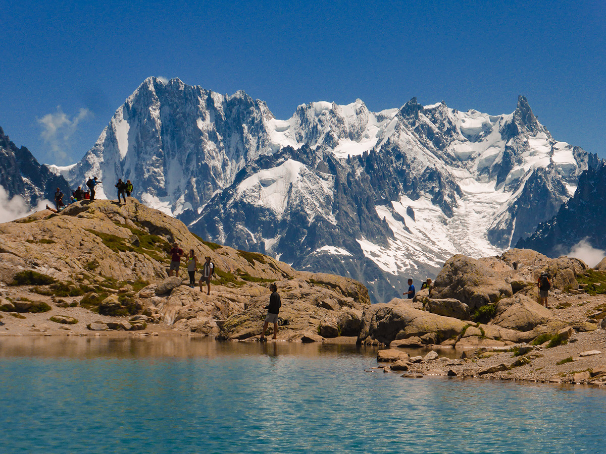 Group of hikers near the lake on Tour de Mont Blanc in French Alps