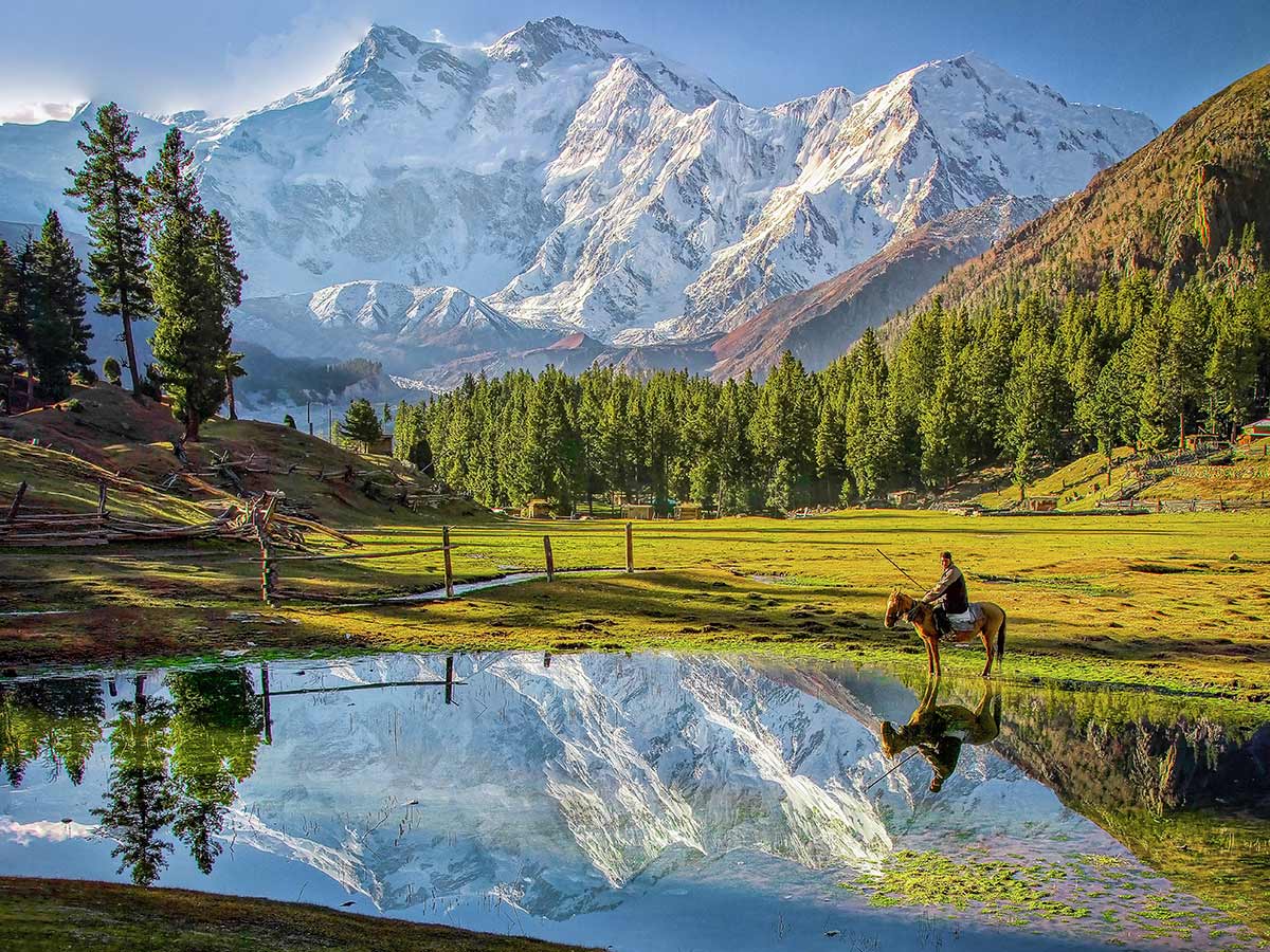 Beautiful mountains, lake and man on a horse on Fairy Meadows and Nanga Parbat Base Camp Tour in Pakistan