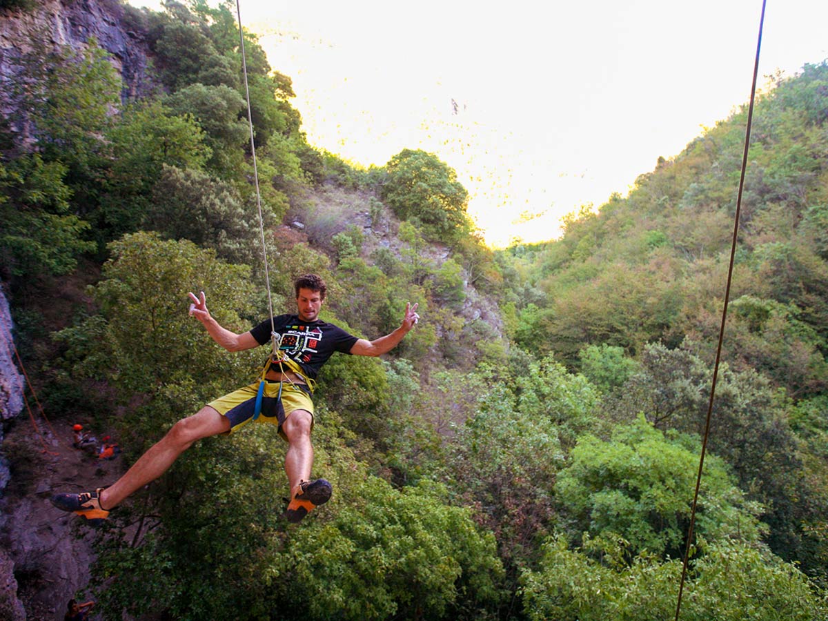 Climber rappelling down on climbing camp in Italian Riviera