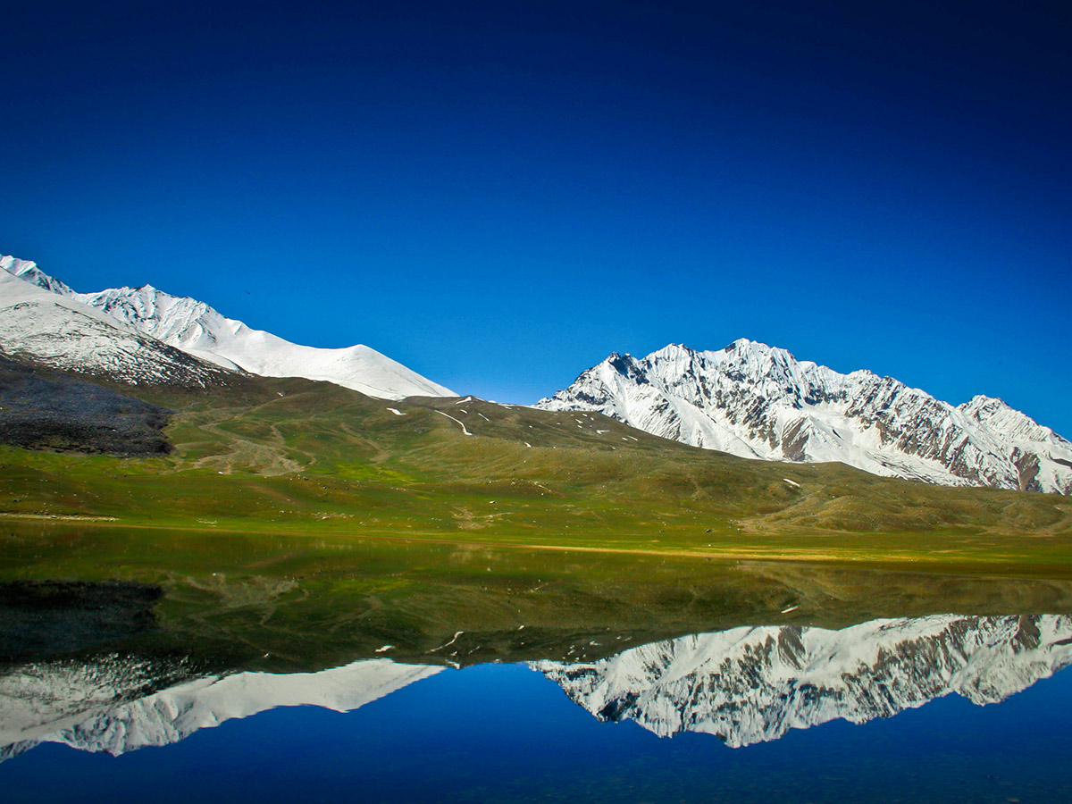 Reflections on Shandur Lake on Chitral Valley Overland Tour in Pakistan