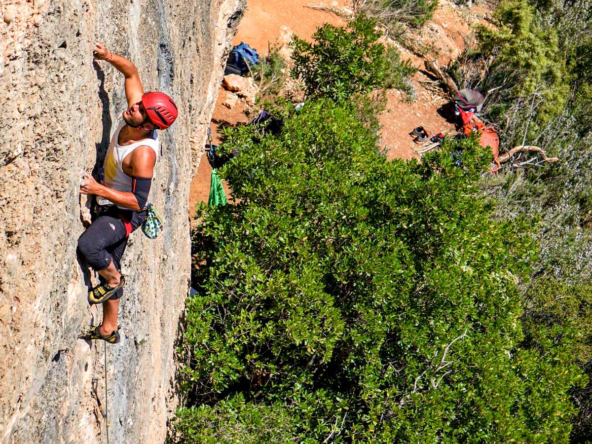 Climber on vertical rock wall on rock climbing tour in Margalef, Spain