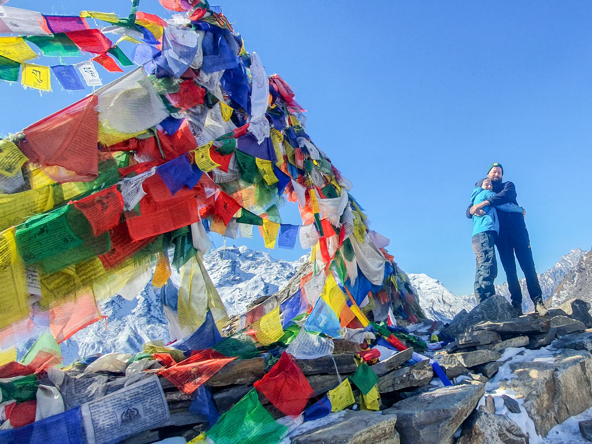 Two hikers and prayer flags on guided Langtang Trek in Nepal