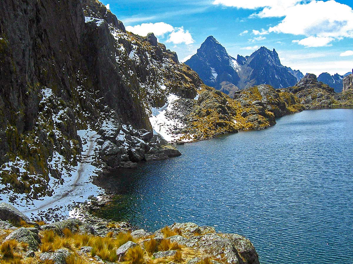 Shoreline of a mountain lake with jagged mountains surrounding it