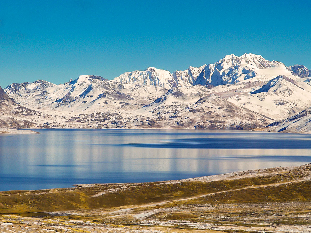 Wide blue lake with snow-covered mountains surrounding it