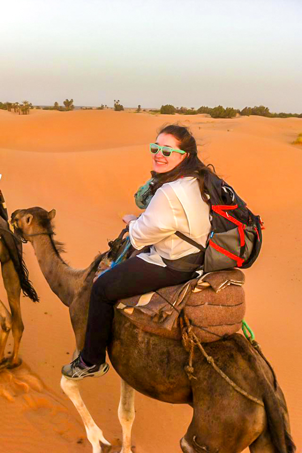 Happy trekker riding a camel on Erg Chigaga Tour in Morocco