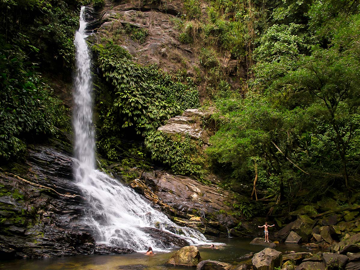 Swimming under the waterfall on Lost City Trek in Colombia