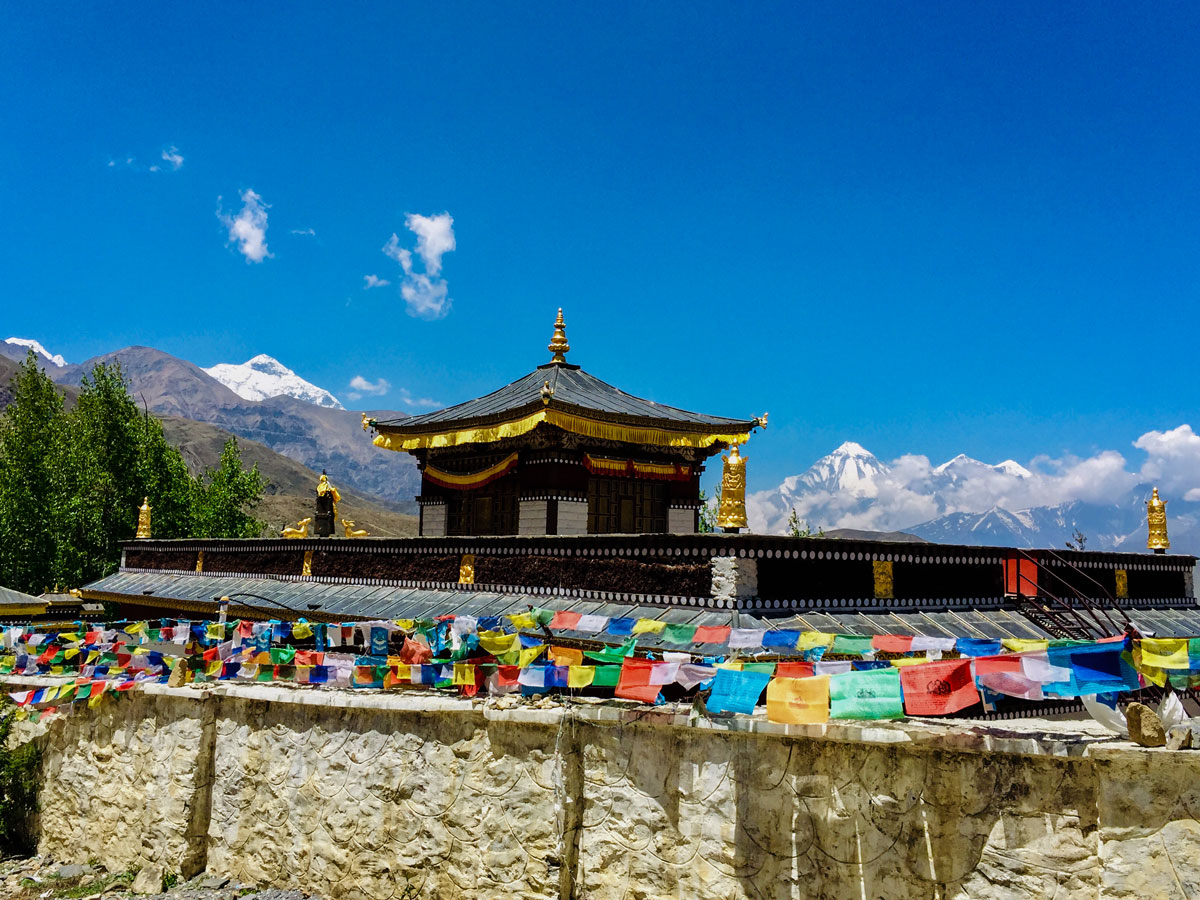 Prayer flag and local building on Annapurna Cycling tour in Nepal