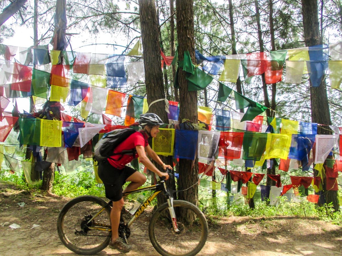 Biker and prayer flags on Cycling around Kathmandu Tour in Nepal