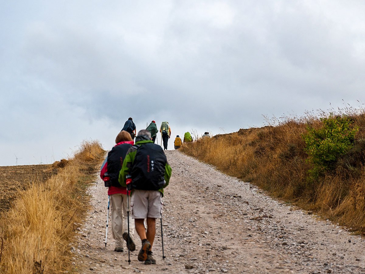 Group of hikers on Camino de Santiago trail approaching Santiago de Compostela