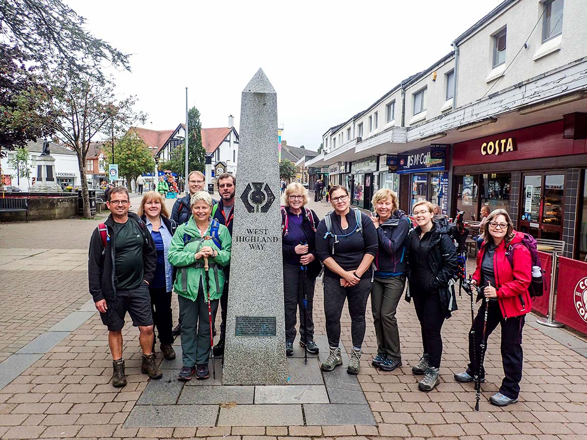 Group of walkers posing on the waypoint of West Highland Way walking tour
