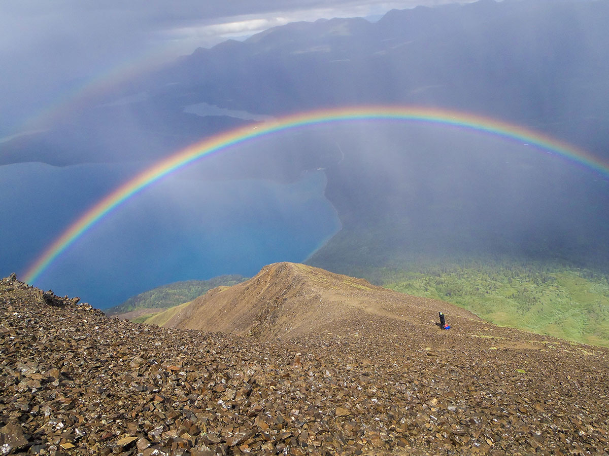 Raibow on a mountain over the valley in Canadian Rockies