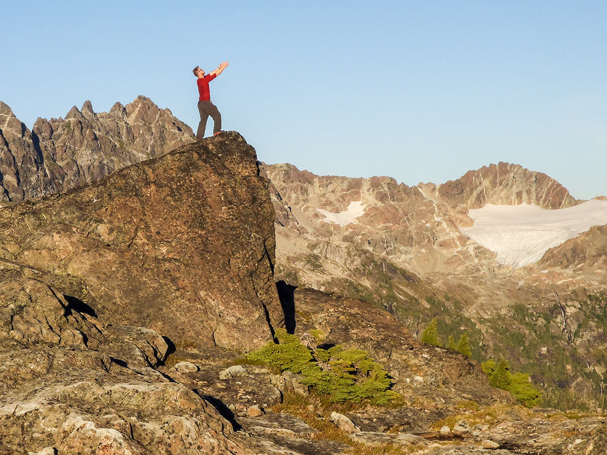 Hiker posing on a small peak in Vancouver Island on a guided tour