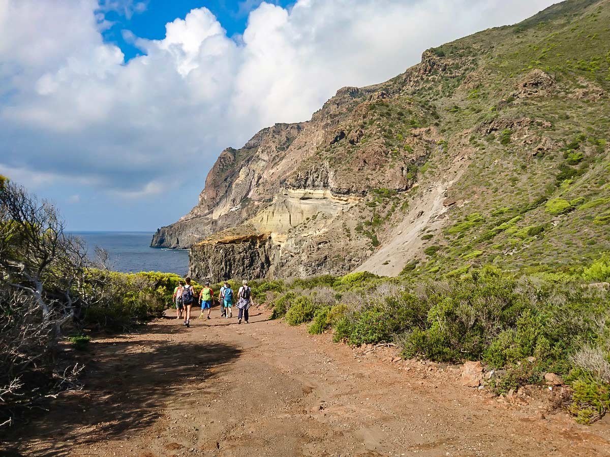 Group of hikers approaching the Mediterranean Sea in the Pantelleria Island (Italy)