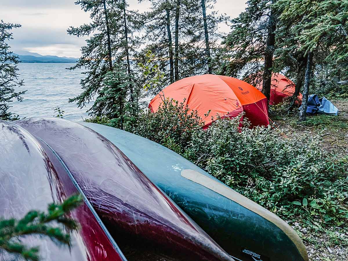 Canoes and tents along the Yukon River, on guided Yukon River Canoeing Tour