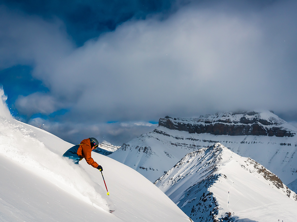 Riding down the steep mountain on a powdery snow