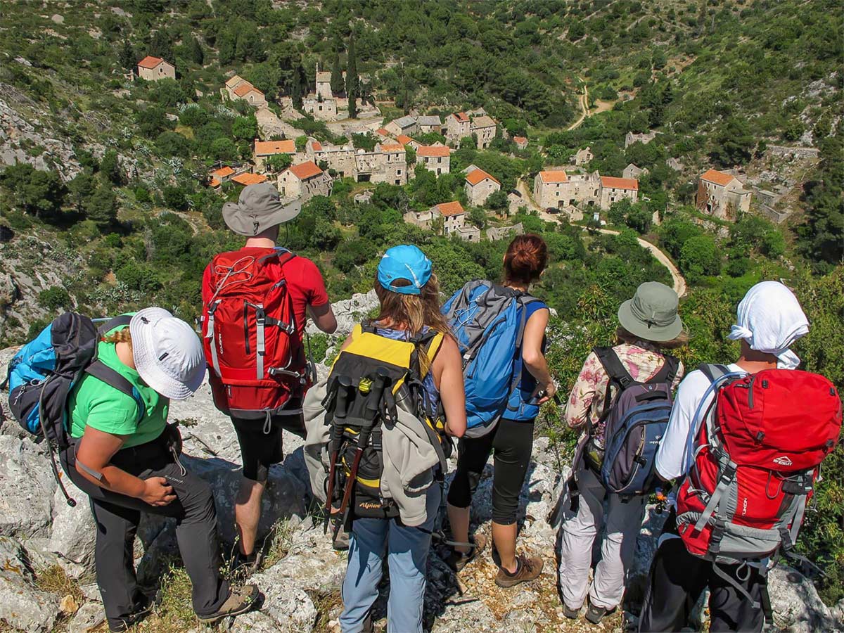 Group of hikers looking down on one of the lost villages on a hike in Hvar Island