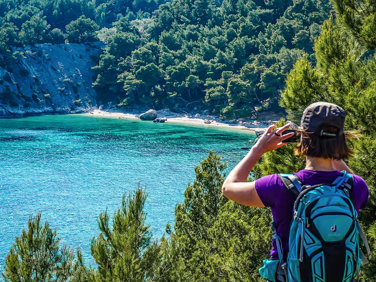 Hiker taking photos of the small secluded beach in Croatia on self guided hiking tour from Split to Dubrovnik