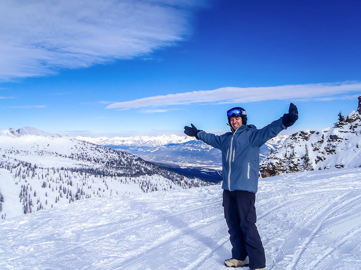 Skier posing in front of the beautiful scenery on a guided skiing trip to British Columbia