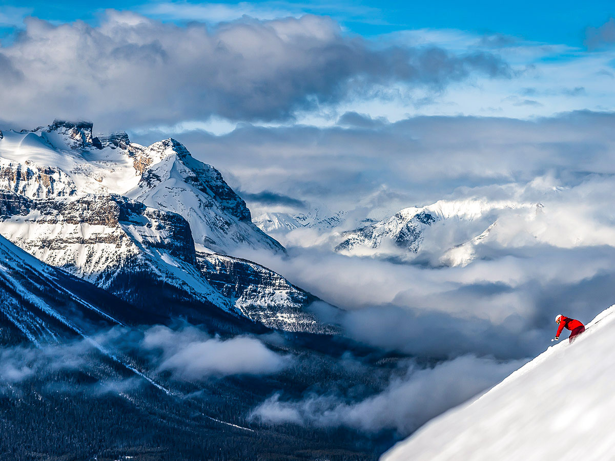 Skiing down the steep mountain in front of the stunning mountain views of the Canadian Rockies