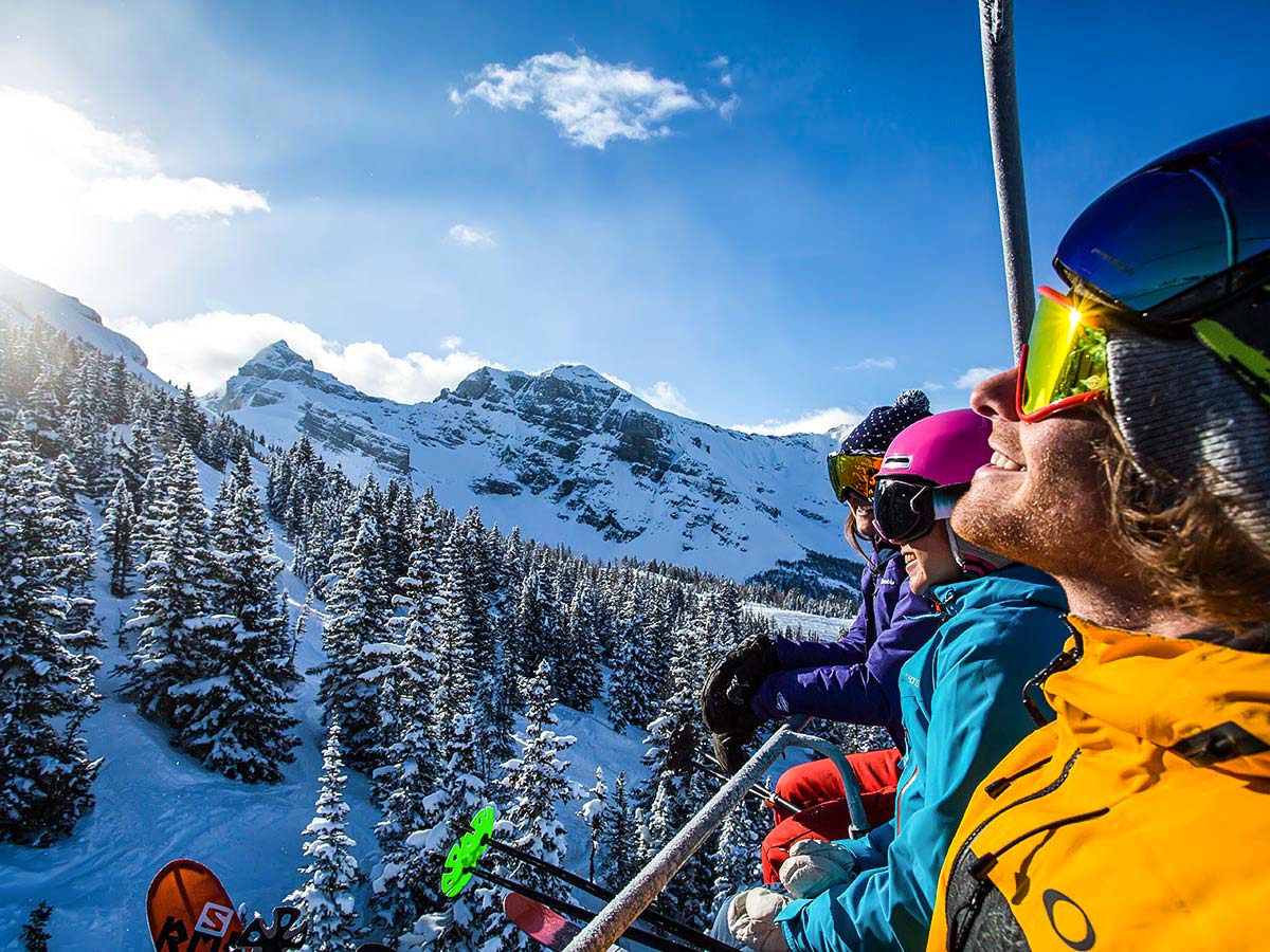 Skiers enjoying the sun while going up the mountain in British Columbia