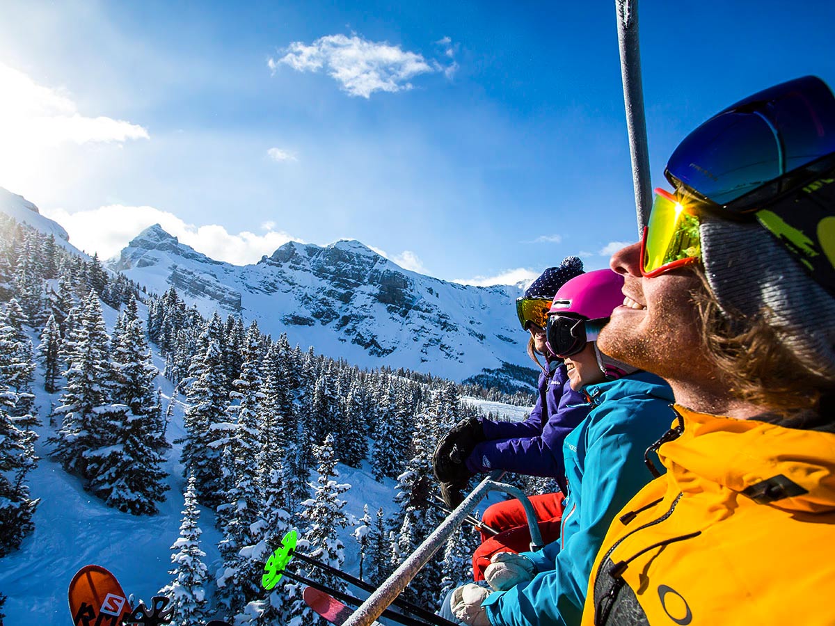 Happy skiers going up the mountain on a skiing trip to British Columbia