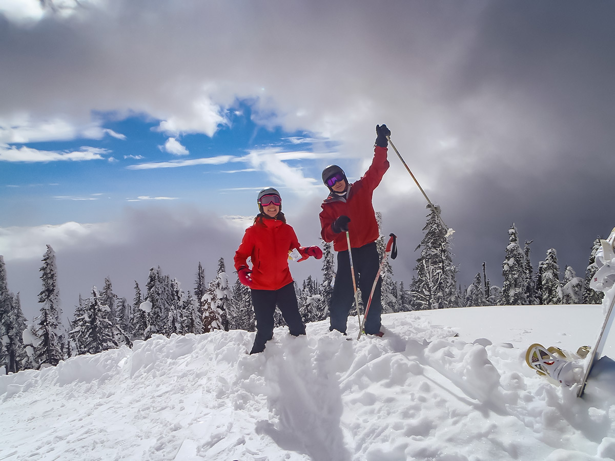 Clowdy sky and two skiers in powdery snow in Canada