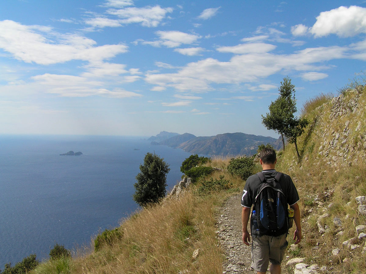 Hiker walking along the Mediterranean Sea coast on self guided Amalfi and Capri walking tour