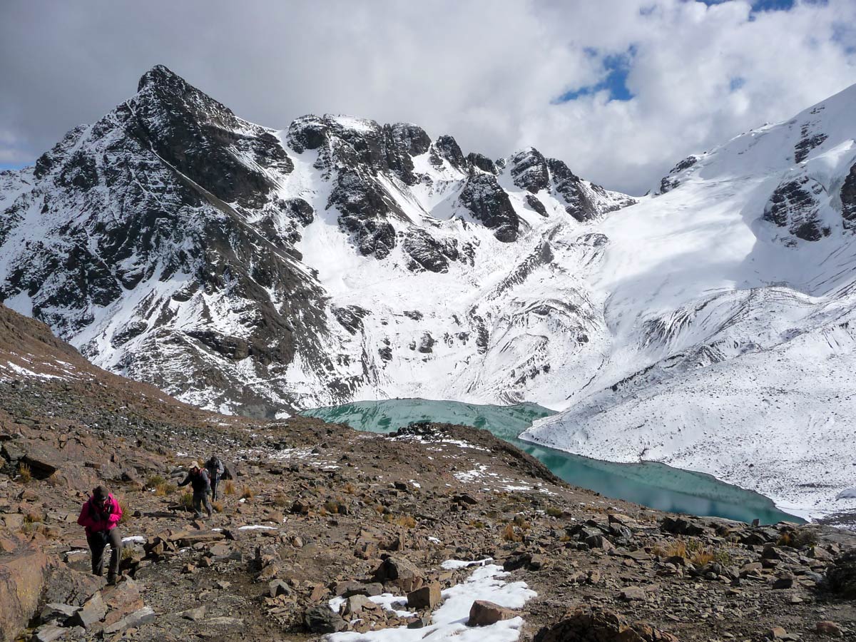 Hikers approaching the alpine lake on Condoriri trek in Bolivia