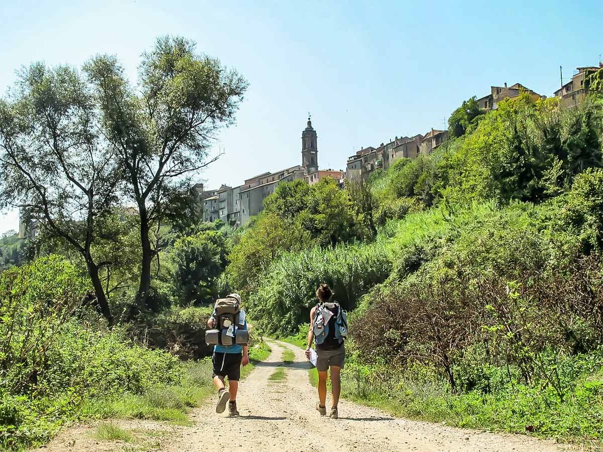 Two hikers reaching Campagnano on Via Francigena piligrimage from Orvieto to Rome