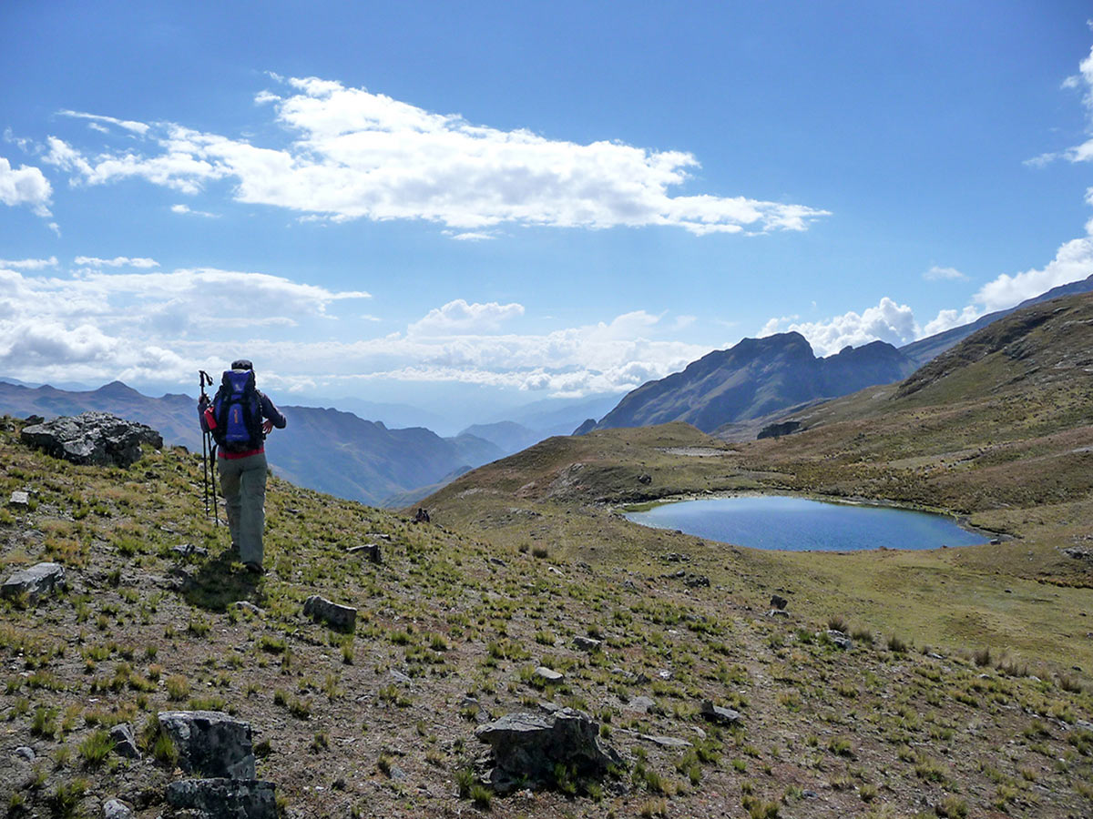 Hiker on Cordillera Real Trek in Bolivia route looking at mountain lake