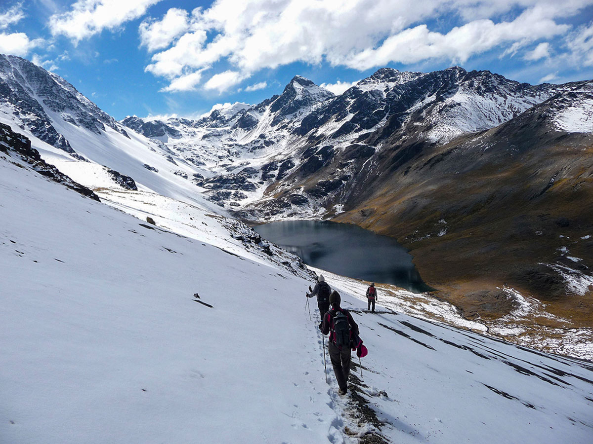 Hikers trekking on the snowy path of guided Cordillera Real Trek in Bolivia