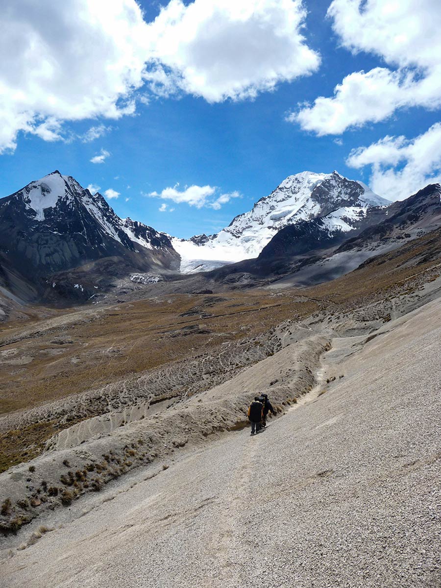 Hikers on trekking path in Royal Cordillera mountain ridge in Bolivian Andes