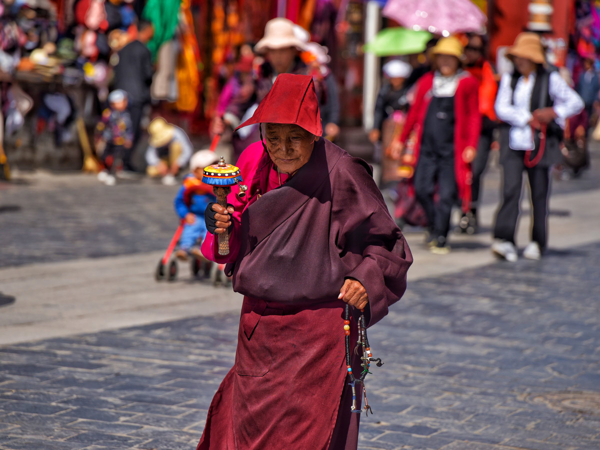 Old woman in ceremony on Barkhor Street seen niking in Tibet