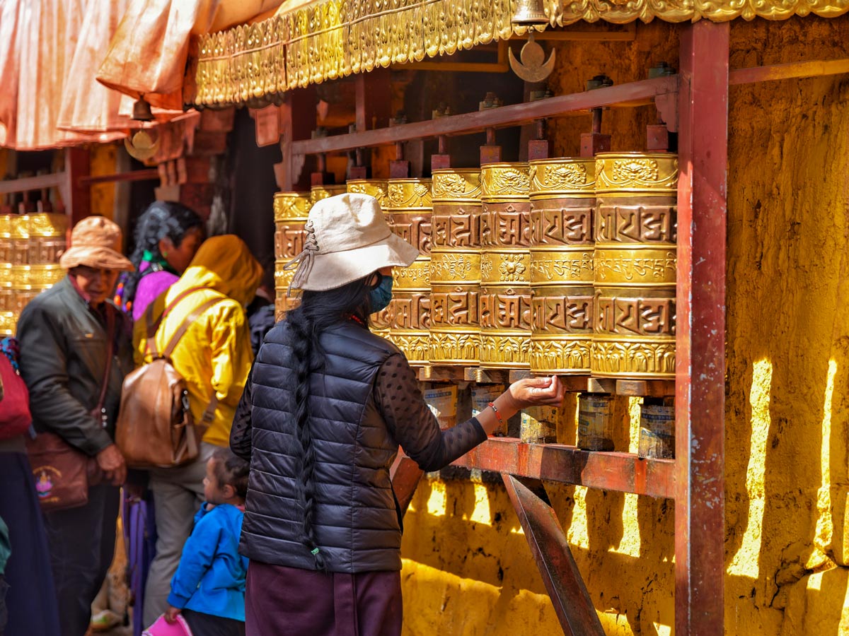 Locals spinning prayer wheels in Barkhor seen along mountain bike tour in Tibet