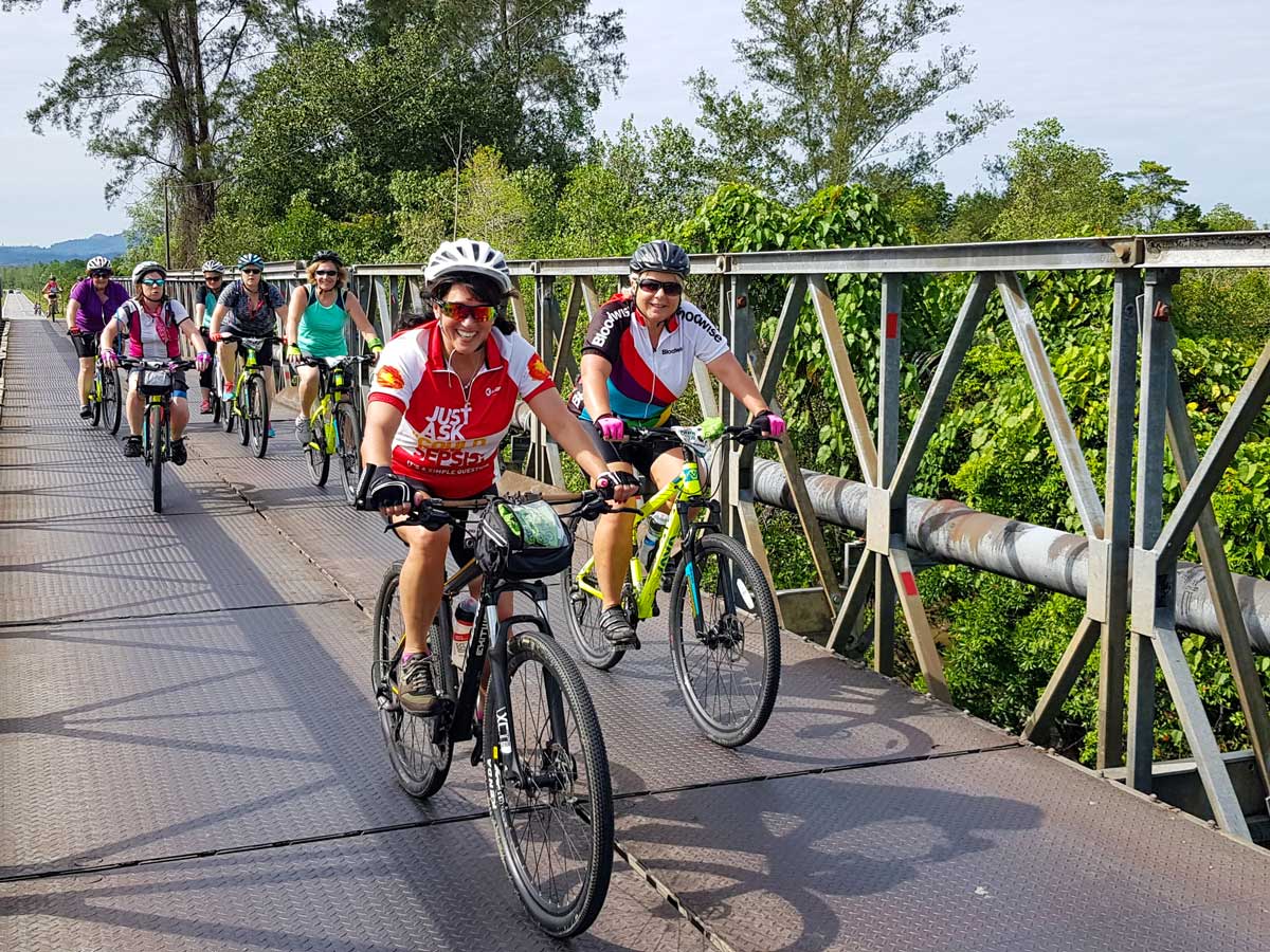 Cyclists biking along Malaysian rainforest ride