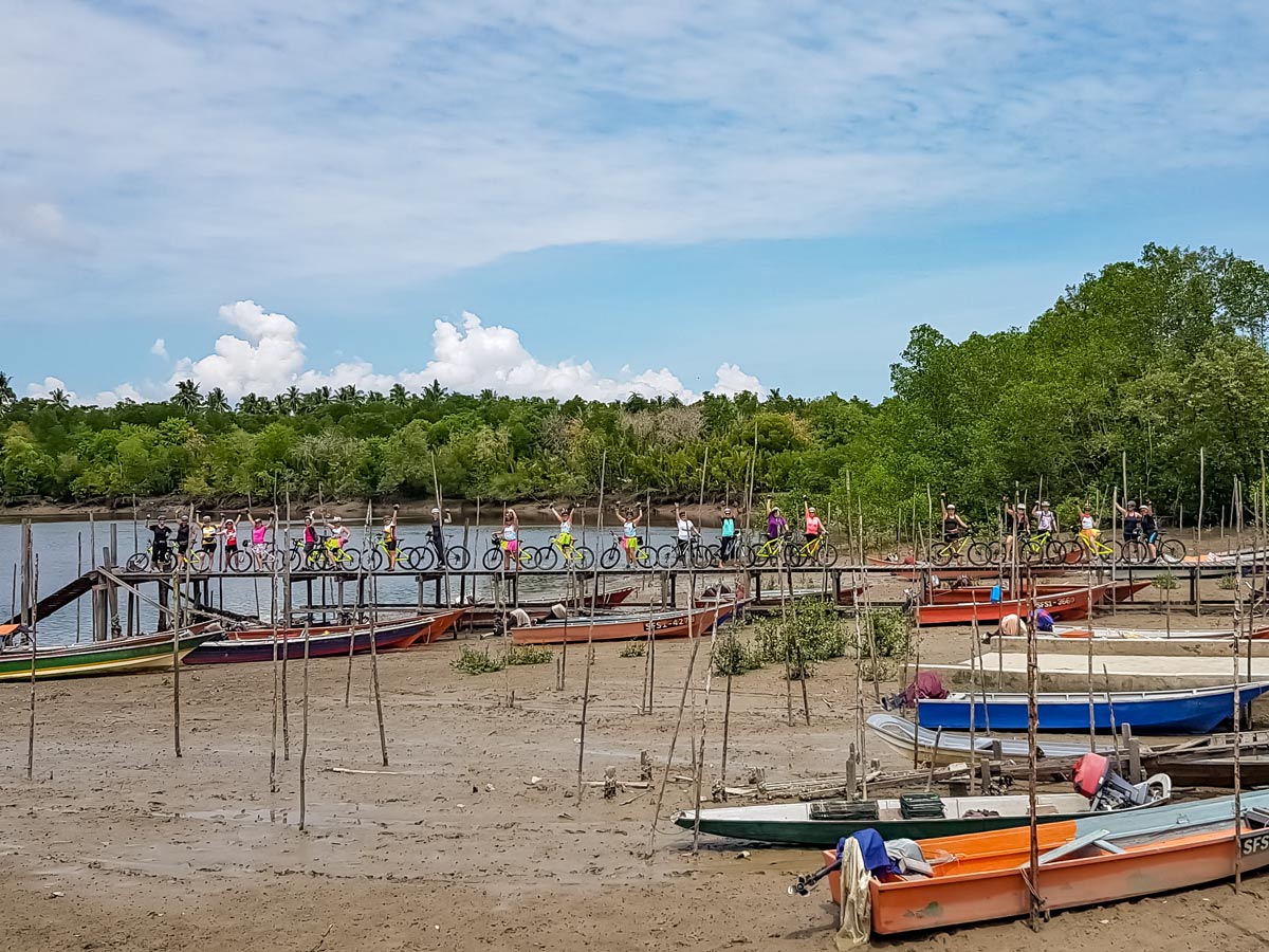 Cyclists on boat dock along Malaysian rainforest ride