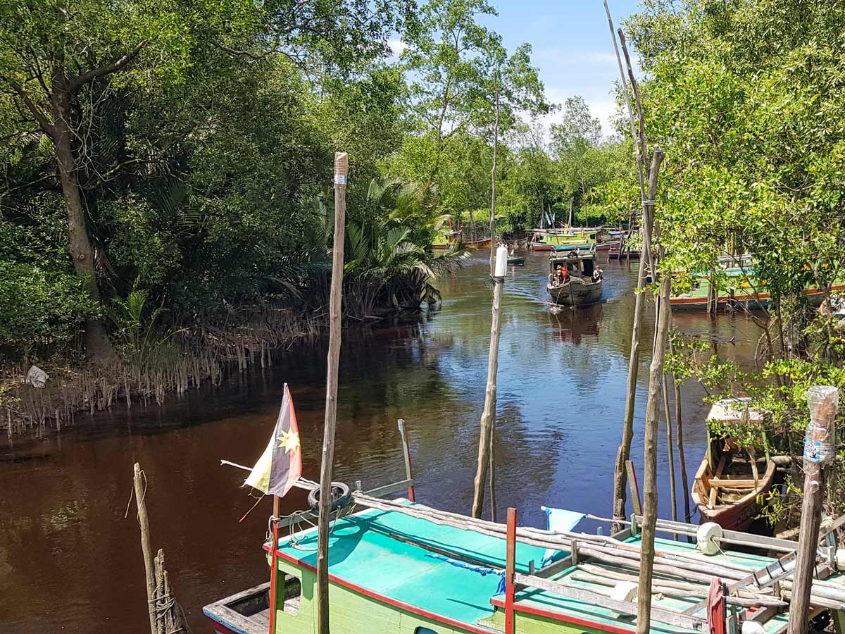 Boats on the river seen along Trans Borneo road bike tour Malaysia