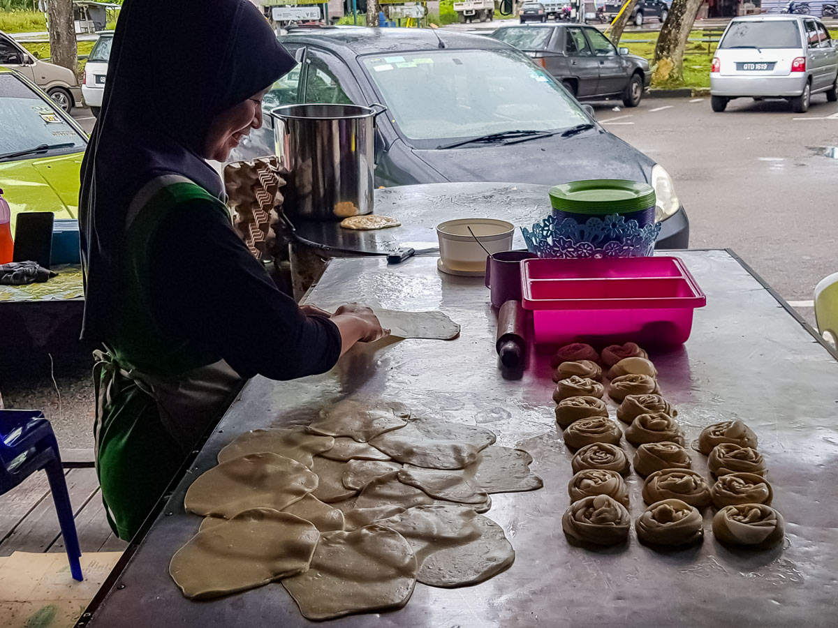 Local woman making pastries along Trans Borneo road bike tour Malaysia