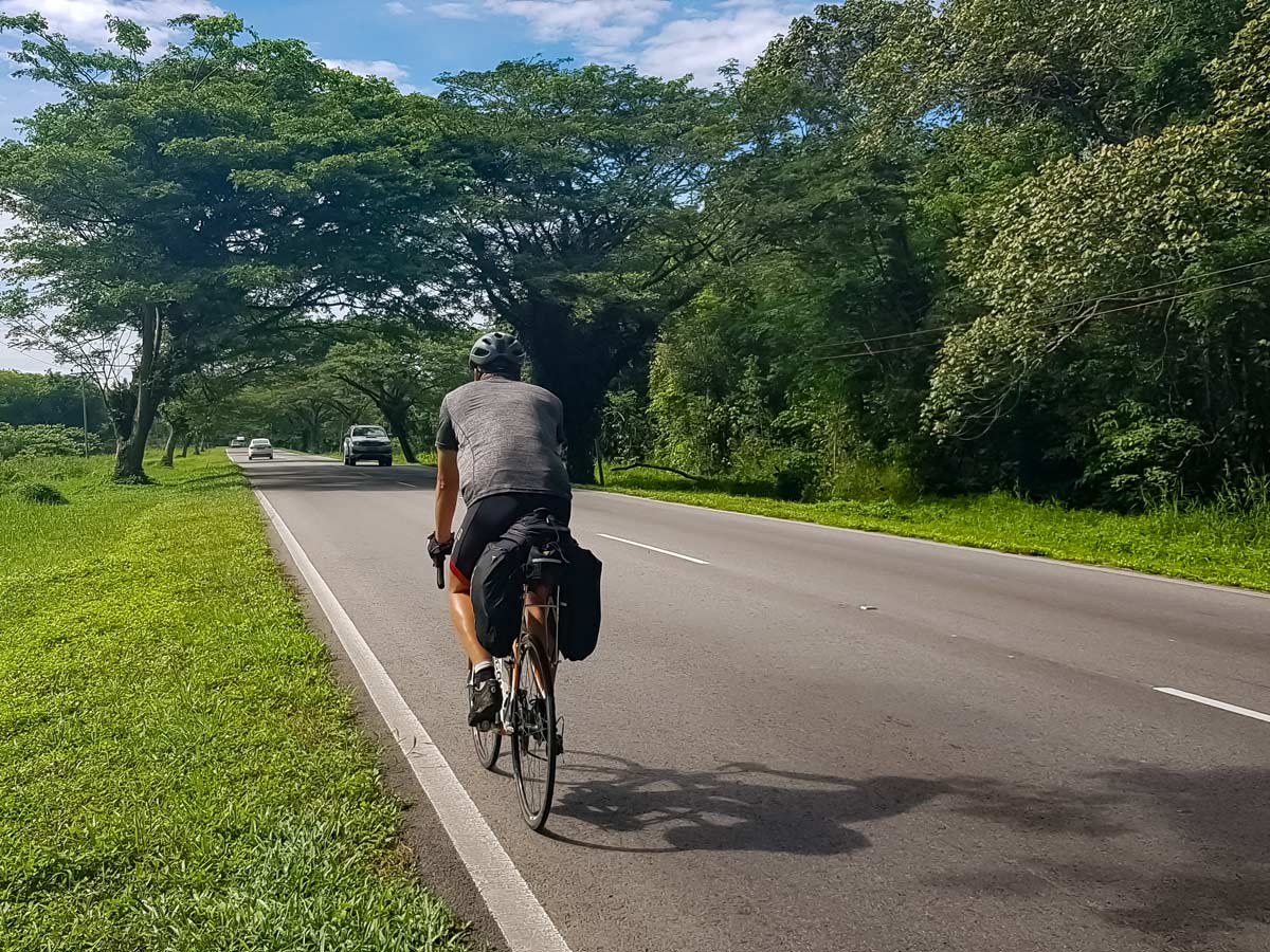 Cyclist road biking along Trans Borneo bike tour Malaysia