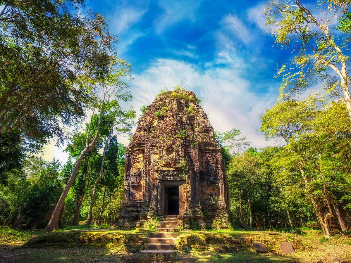 Sambor Prei Kuk temple ruins with giant banyan trees under blue sky