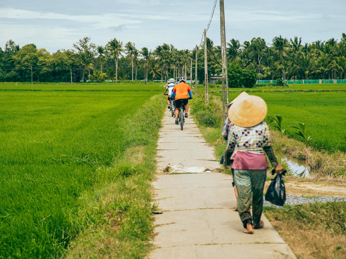 Bikers on a path between Mekong Delta and Angkor Wat