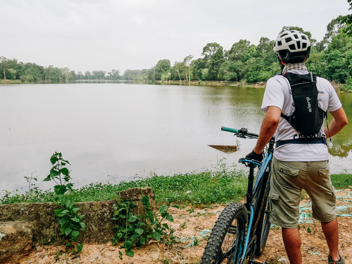 Biker looking at the lake on the way to Angkor Wat