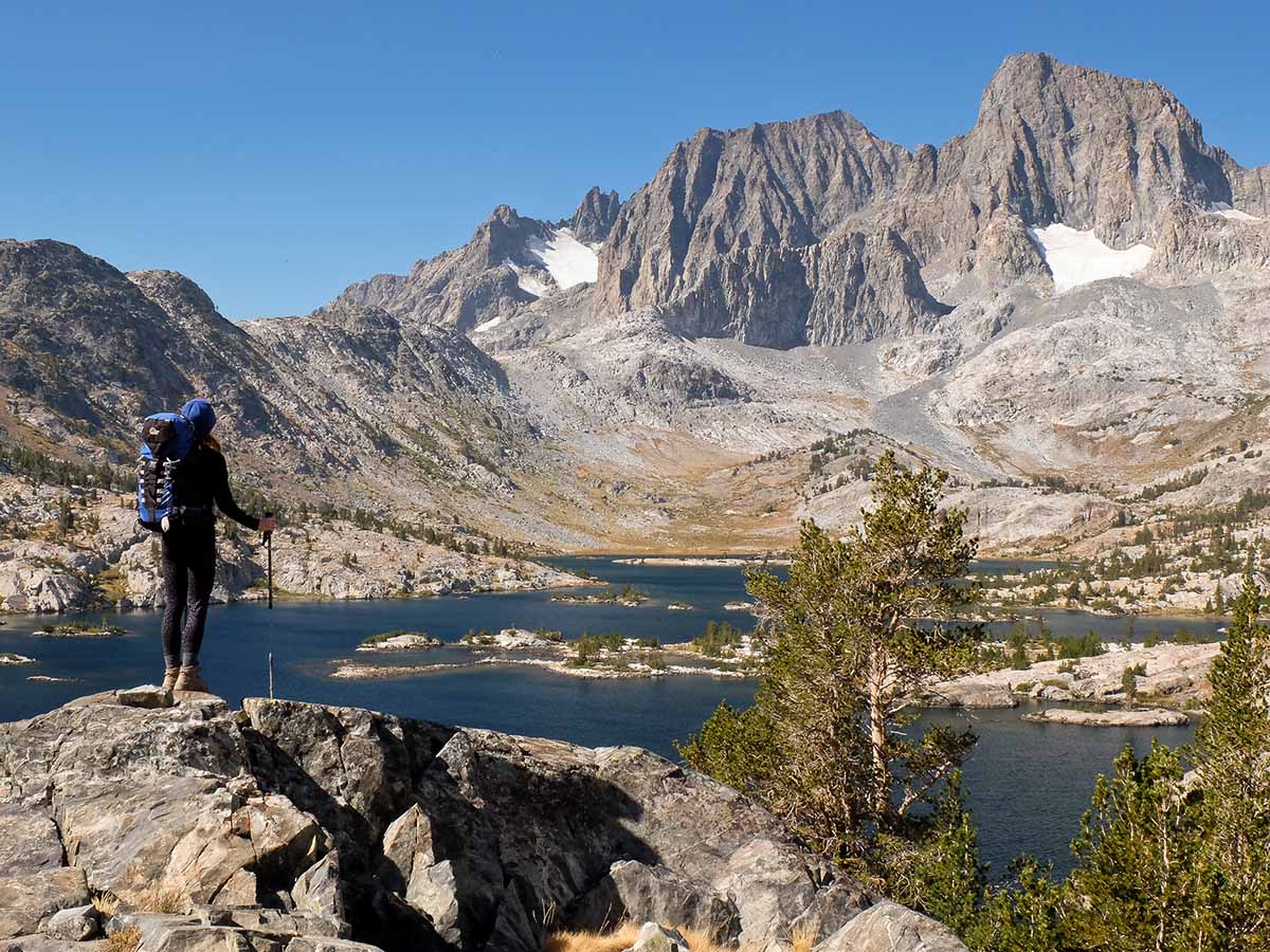 Hiker looking at lake in High Sierra Mountains (California)