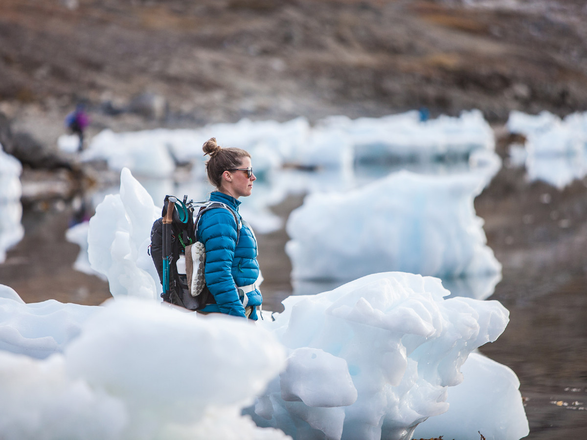 Hiker surrounded by ice boulders in Greenland